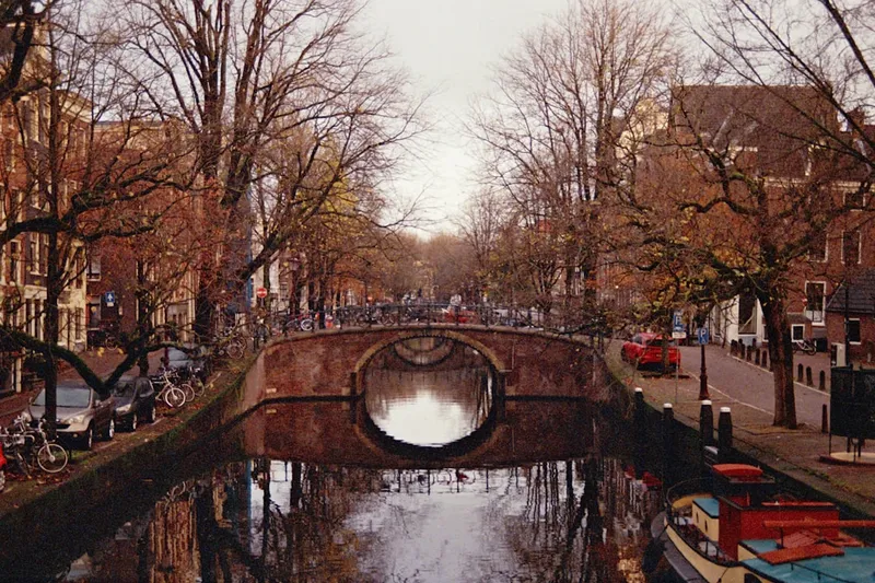 Amsterdams kanalring med smala 1600-talshus reflekterade i vattnet vid solnedgång