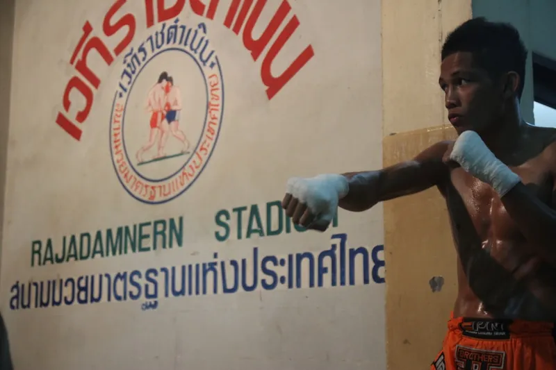 Muay Thai-match på Lumpinee Stadium i Bangkok med boxare och publik