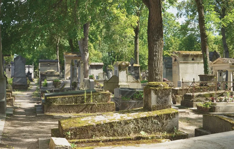 Père Lachaise kyrkogård i Paris med klippiga gravstenar och cypresser