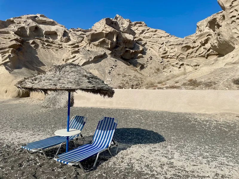 Vlychada strand på Santorini med dramatiska vita pimpsten-klippor och svart sand